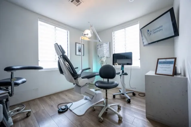 A bright dental treatment room with a chair and overhead light