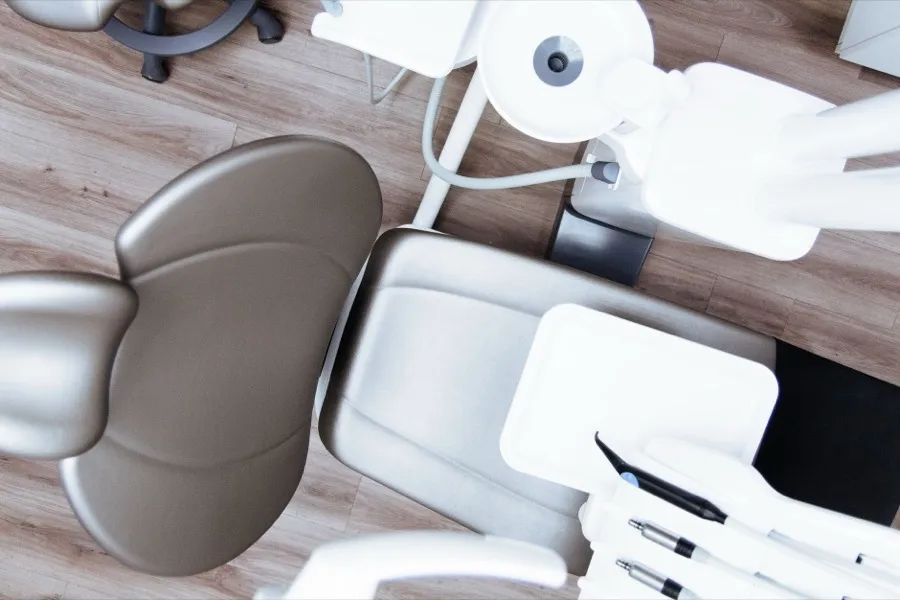 A dental chair and overhead light seen from above